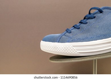Blue sneakers on a rack for sale on a brown background with copy space. The concept of selling a new shoe collection. close-up - Shutterstock ID 1114690856