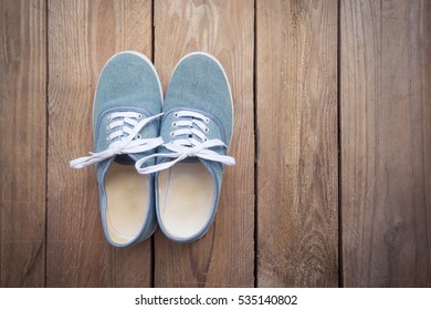 Blue sneakers on wooden background with copy space,Top view,Vintage effect.