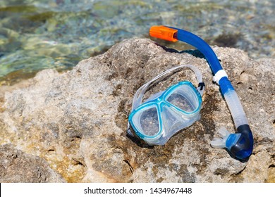Blue Snorkle Or Diving Mask Located On The Rocks
