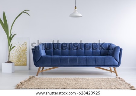 Blue sofa and wicker carpet in white simple living room