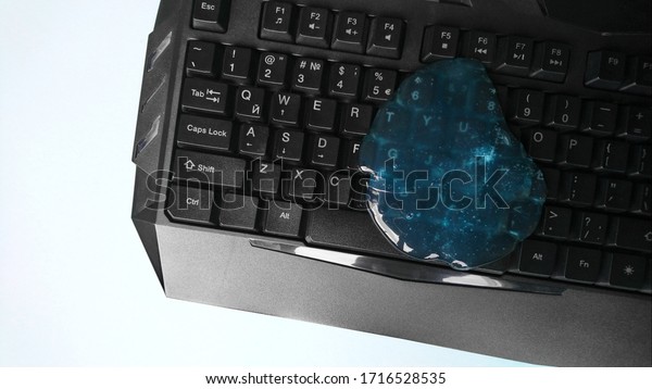 Blue soft gel\
cleaning dust on keyboard. Concept cleaning your computer\'s\
keyboard. Office cleaning.
