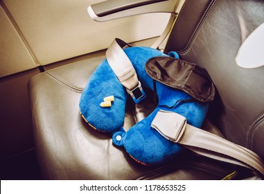 Blue Soft Traveling Pillow, Noise Removing Ear Plugs And Sleeping Mask, In Plane Cabin On Passenger Seat, Comfortable Cozy Traveling Concept, Composition.