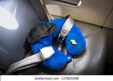 Blue Soft Traveling Pillow, Noise Removing Ear Plugs And Sleeping Mask, In Plane Cabin On Passenger Seat, Comfortable Cozy Traveling Concept, Composition.