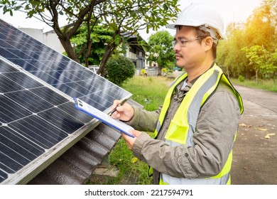 Blue Solar Photo Voltaic Panels System Of Apartment Building On Sunny Day. Renewable Ecological Green Energy. Maintenance Panels Collect Solar Energy. Engineer Holding Clip Board