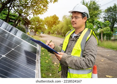 Blue Solar Photo Voltaic Panels System Of Apartment Building On Sunny Day. Renewable Ecological Green Energy. Maintenance Panels Collect Solar Energy. Engineer Holding Clip Board