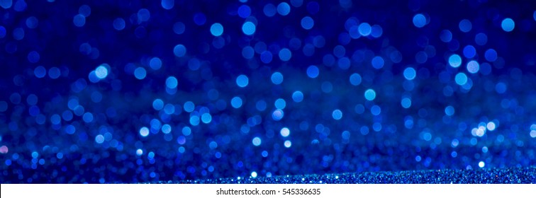 blue Sparkling Lights Festive background with texture. Abstract Christmas twinkled bright bokeh defocused and Falling stars. Winter Card or invitation.