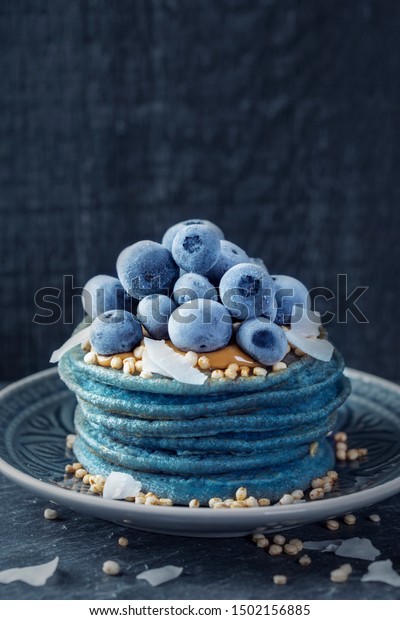 ピーナッツバター ブルーベリー ココナツチップが載った青いスピルリーナのパンケーキ の写真素材 今すぐ編集