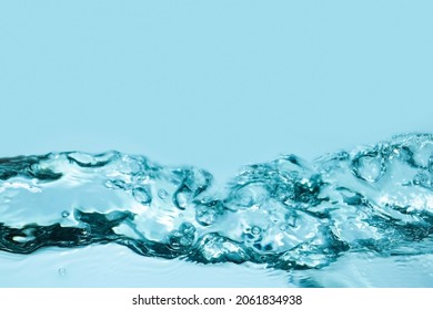 Blue splashing cosmetic moisturizer, micellar water, toner, or emulsion abstract background. Transpatent texture with bubbles