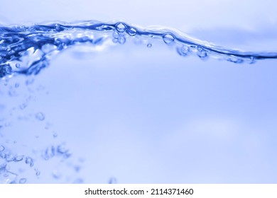 Blue splashing cosmetic moisturizer, micellar water,  toner, or emulsion abstract background. Transpatent texture with bubbles