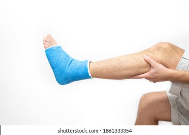 Blue Splint Ankle. Bandaged Leg Cast On Male Patient On White Background Isolated. Sports Injury Concept.