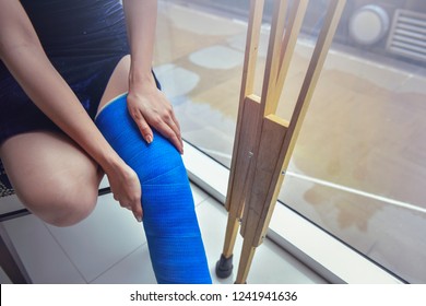 Blue Splint Knee. Bandaged Leg Cast And Toes After A Running Injury Accident.Young Woman In Blue Plaster Cast. Cropped Shot Of A Girl Holding Her Leg In Pain. Shin Splints.