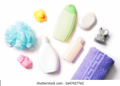 Blue Sponge, White Shampoo Bottle, Green Shower Gel, Body Lotion, Soap Bar, Rubber Toys And Purple Cotton Bath Towel. Flat Lay Photo Baby Care Cosmetics, Toiletries Set