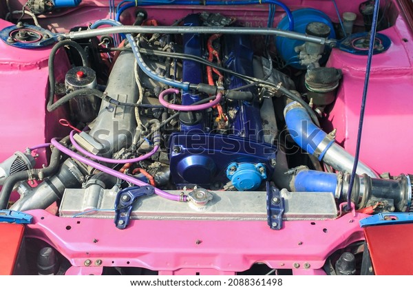 Blue sports car engine, lots of tubes and\
wires. Under the hood of the drift\
car