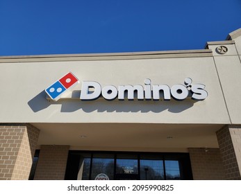 Blue Springs Missouri USA- December 16 2021: Sign Above Building Entrance For Domino's Pizza Parlor Beneath Blue Sky