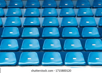Blue stadium seats with number. Empty plastic chairs in stadium.