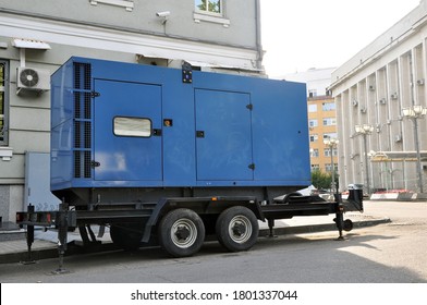 Blue standby mobile diesel generator for office building connected by cable wire to office building