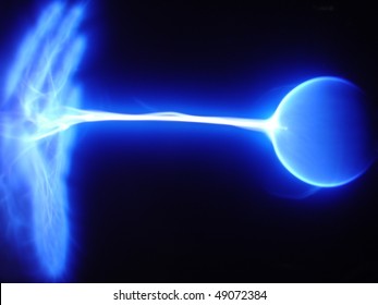 Blue static electricity arc traveling from a plasma ball to an open hand.  Horizontal shot.