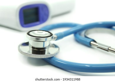 Blue stethoscope and infrared thermometer on white background. Medical devices For treatment. Healthcare concept. 