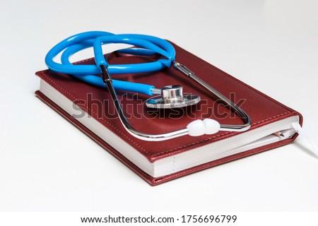Blue stethoscope lying on the diary, medicine.
