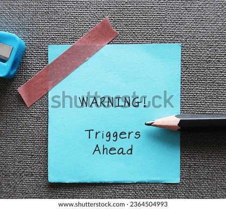 Blue stick note with handwritten text WARNING! triggers ahead - concept of knowing your triggers, to aware or identify emotion triggers when encountering something difficult