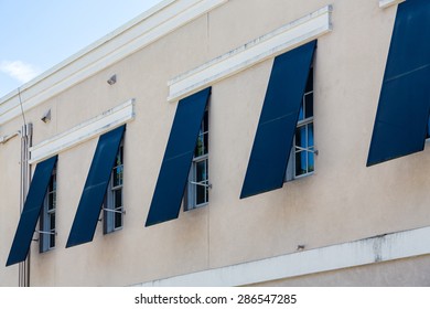 Blue Storm Shutters Open On A New Stucco Building