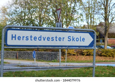 A Blue Street Sign Giving Information To A Danish School