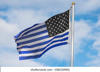 A Blue Striped Flag Being Rasied In Support Of Fallen Police Officers.