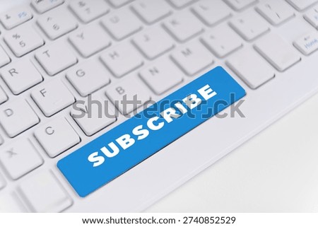 Blue subscribe button on keyboard representing online signup, audience growth and marketing.