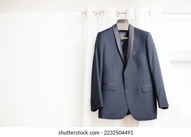 Blue suit hanging. Wedding preparation fashion background. Gentelman formal wear.