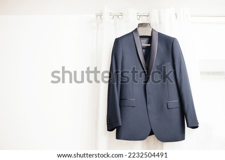 Blue suit hanging. Wedding preparation fashion background. Gentelman formal wear.