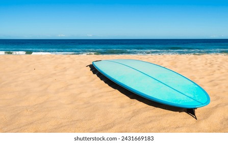 Blue surfboard on sandy beach, blue ocean and blue sky background - Powered by Shutterstock