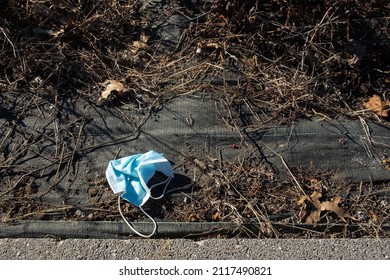 Blue Surgical Mask Abandoned On The Ground After Being Used During The Covid Pandemic