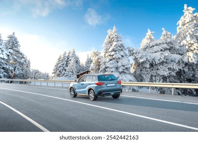 Blue suv car driving on nature road in snowy forest in winter. Snowy winter road landscape in nature trip. Winter travel in mountain road scenery. Winter landscape on the highway in snowy mountains. - Powered by Shutterstock