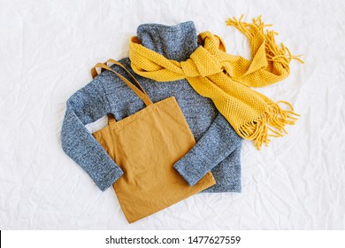 Blue Sweater With Yellow Knitted Scarf And Tote Bag. Autumn/winter Fashion Clothes Collage On White Background. Top View Flat Lay. 