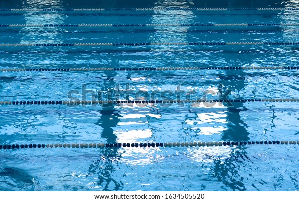 Blue swimming pool with\
lanes.