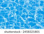 Blue swimming pool water surface and ripple wave background. Summer abstract reflection caustics in swimming pool.