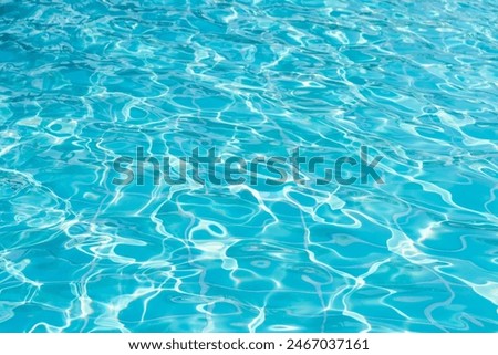 Blue swimming pool water surface and ripple wave background. Summer abstract reflection caustics in swimming pool.