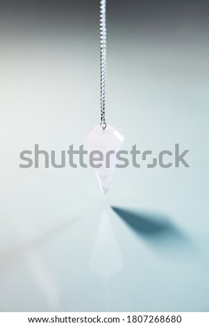 Blue Table with reflections and a crystal pendulum, esoteric and spirituality, copyspace
