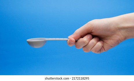 Blue Tablespoon Measuring Spoon Facing Up In Hand