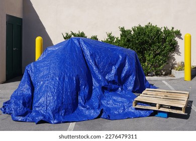 Blue tarp covering a stack of boxes