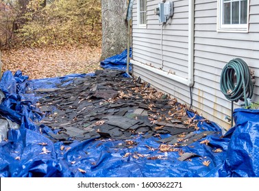 A Blue Tarp Is Filled With Old Shingles Removed From The Roof Of This Home So A New Roof Can Be Put On