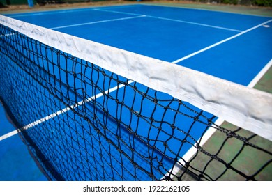 Blue Tennis Court With Net In Fisheye. Empty Sport Field Photo. Hard Cover For Lawn Tennis. Summer Sport Activity Outdoor. White Markup On Blue Court. Sunny Day On Tennis Court. Sport Field In Park