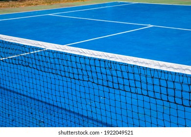 Blue Tennis Court With Net, Sport Field Photo. Lawn Tennis On Hard Court. Sunny Tennis Court Empty Abstract Photo With White Markup And Net. Tennis Game Play Concept