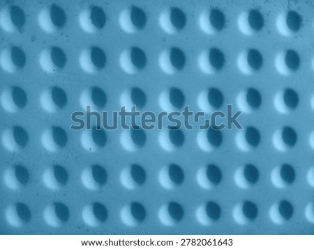 Blue textured background with repeating circular indentations and shadows