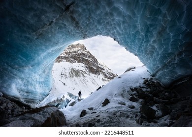 Blue textured ice cave exploration with a silhouette of a hiker in Arolla glacier, Valais Switzerland