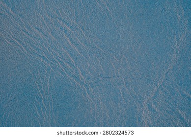 Blue textured surface with subtle light reflections.