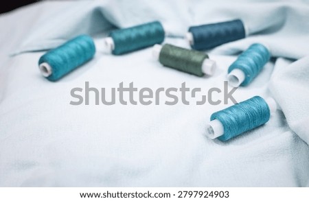 Blue thread spools arranged on white surface, sewing, threads, c
