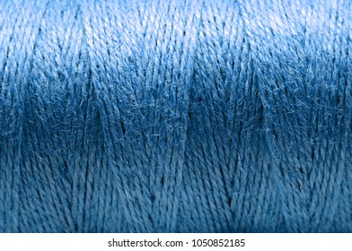 A blue threaded coil texture or background. Close up. Low deph of field.