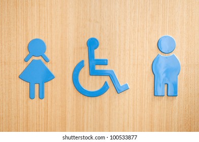 blue toilets WC sign for men, wheelchair and women (wooden background)
