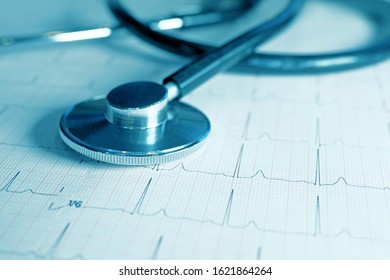 Blue tone medical concept. Cardiogram with stethoscope on table